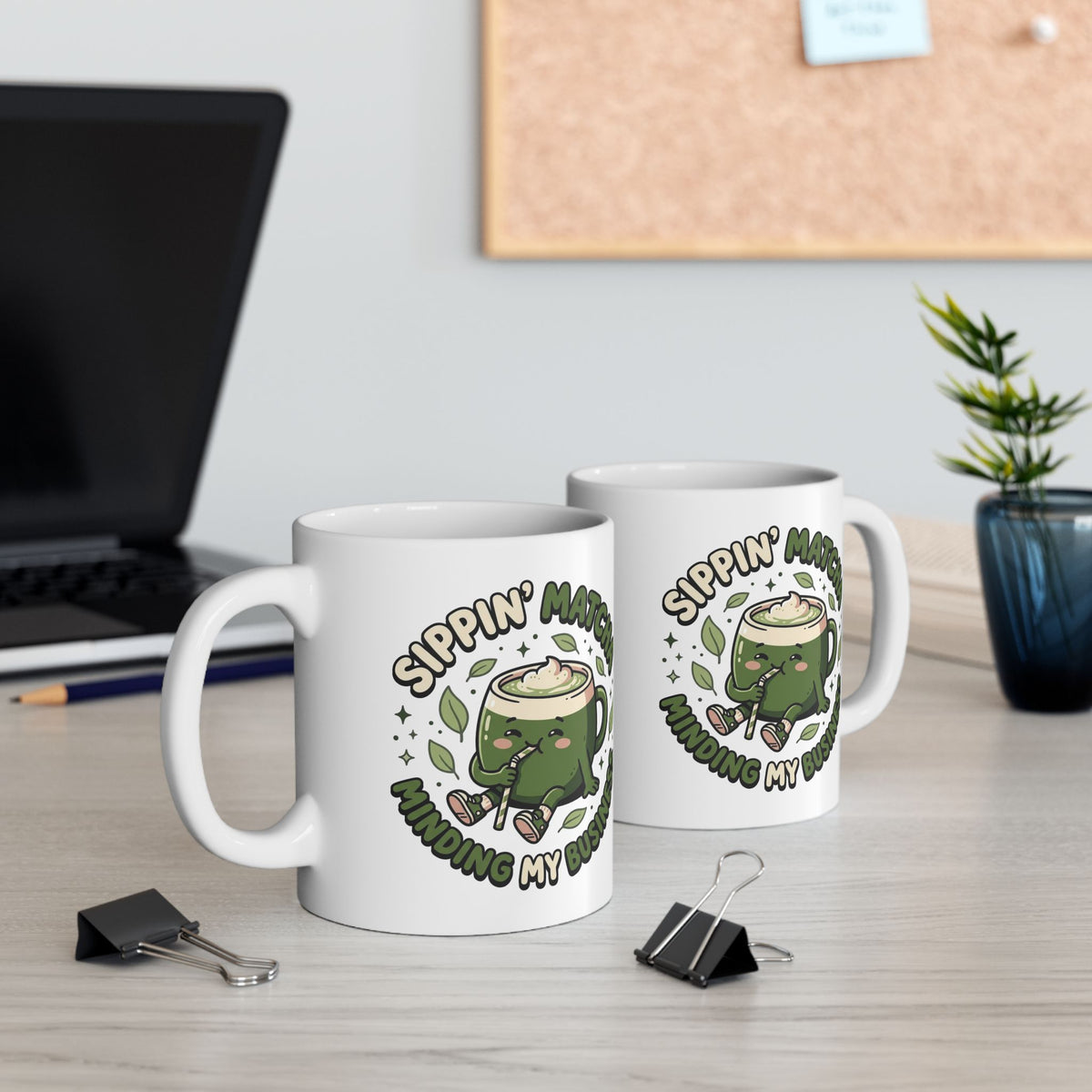 White ceramic matcha mug with a kawaii matcha-cup character and the text “Sippin’ Matcha Minding My Business, view of both sides of the mug