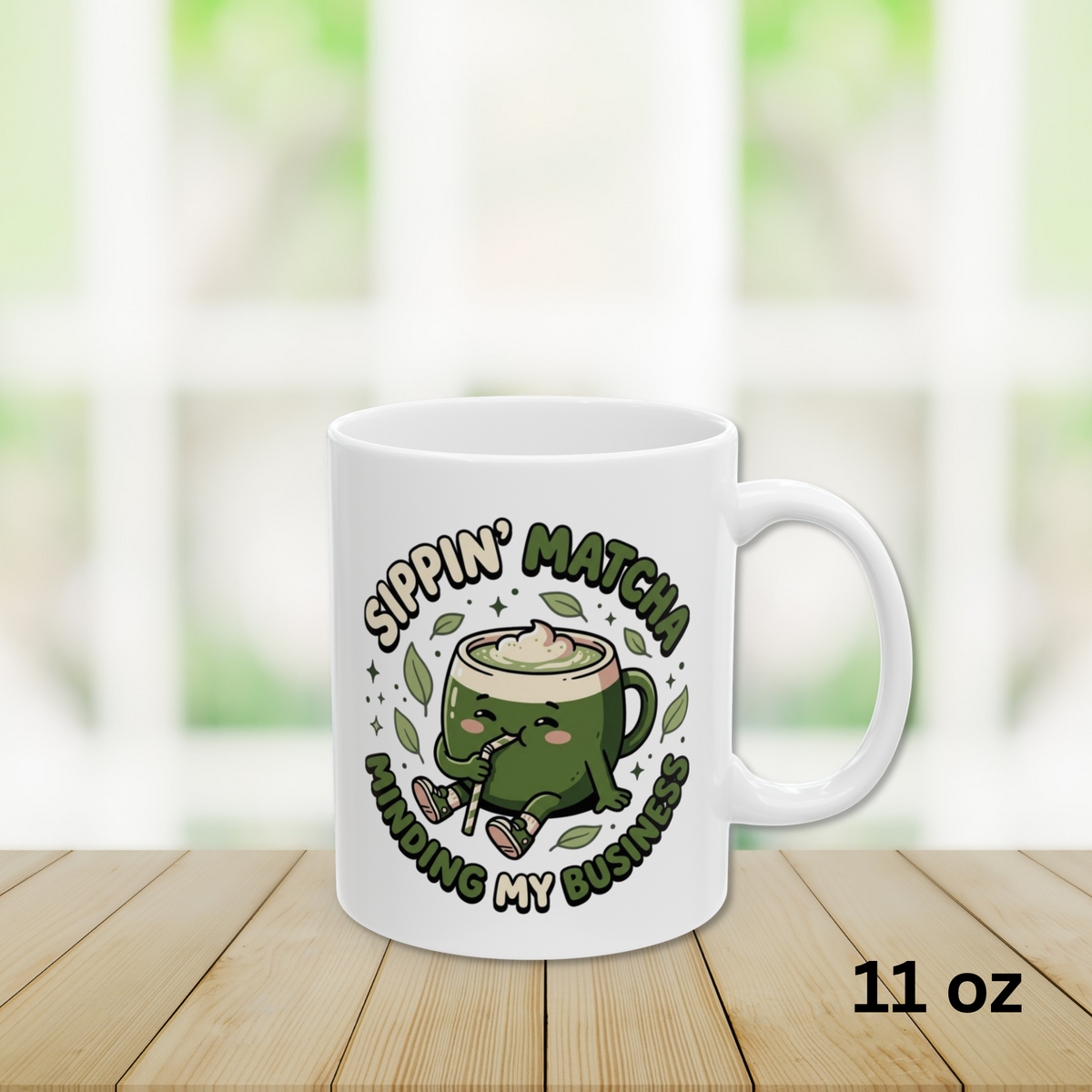 Close-up view 11oz White ceramic matcha mug with a kawaii matcha-cup character and the text “Sippin’ Matcha Minding My Business