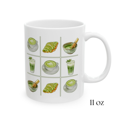 Close-up view of 11oz white ceramic mug with a matcha tic-tac-toe design of green lattes, matcha croissants, iced matcha, and whisked matcha bowls